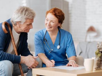 Friendly home care nurse assisting a senior man with personalized care services.