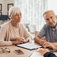 Senior couple consulting a professional to explore home care services, including elderly care, dementia care, and customized care plans.